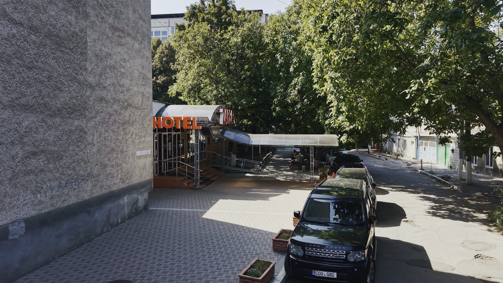 The existing Hotel Zarea entrance and access lane, side view from the September 2026 drone survey